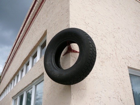 Tom Scicluna, Untitled, 2012, tire hung on preexisting flag mount<br/>
